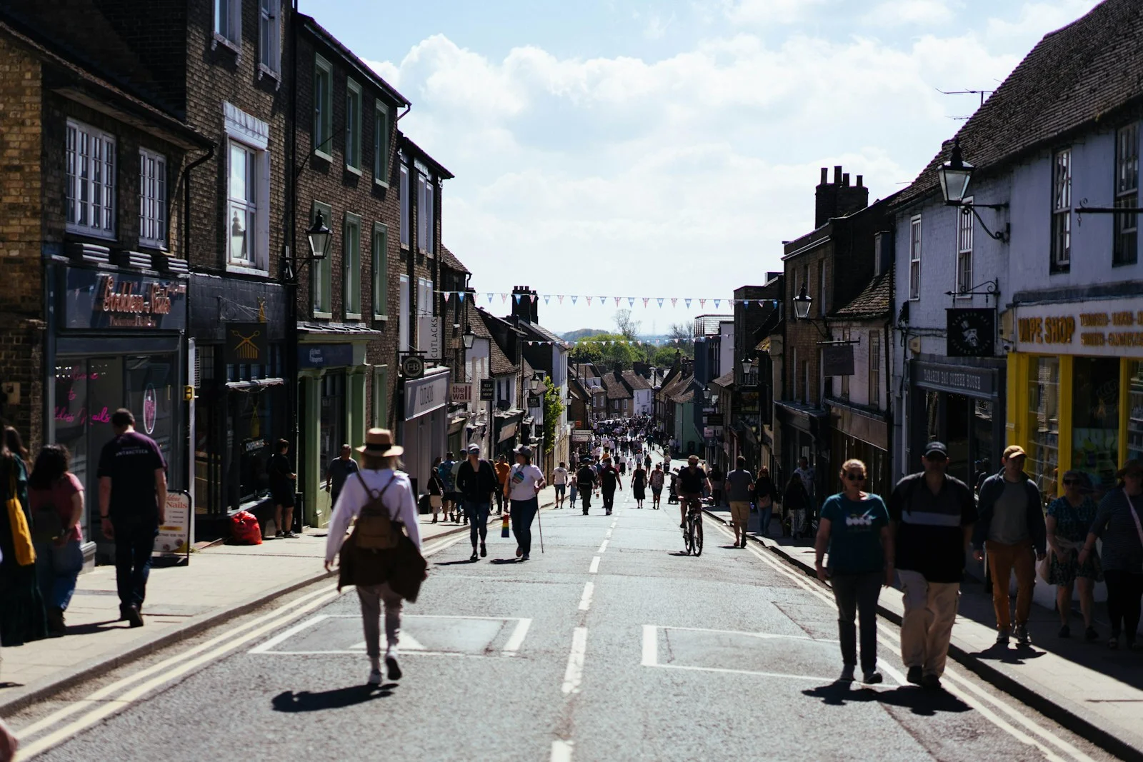 People stroll down a street lined with buildings
