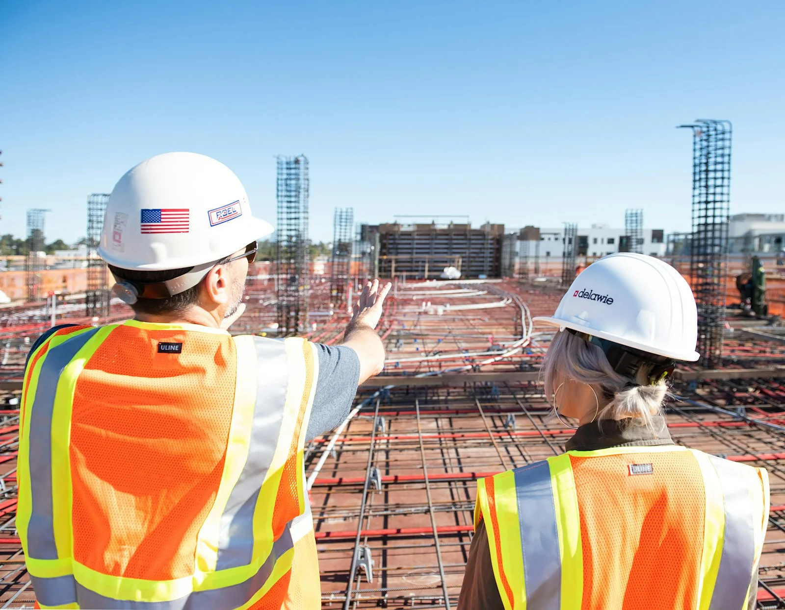 two construction workers in safety vests at site two construction workers in safety vests at site