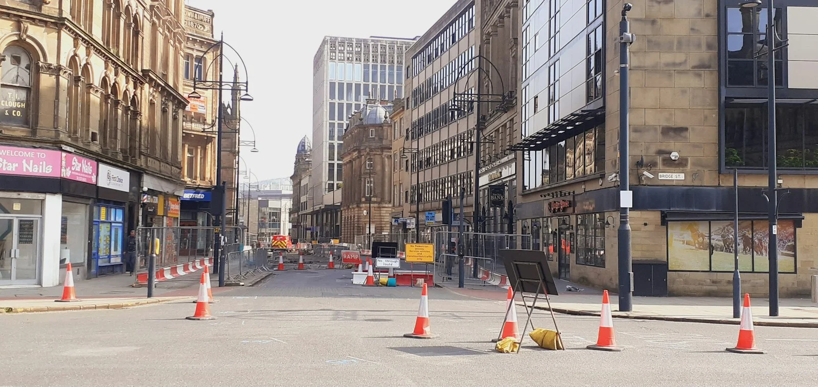 a city street is blocked off by orange cones a city street is blocked off by orange cones